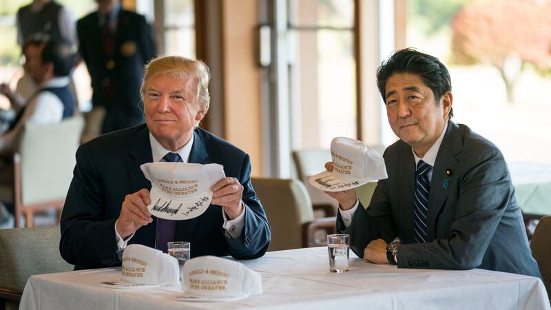 “Donald & Shinzo Make Alliance Even Greater”: Donald Trump and Shinzo Abe with golf hats they signed. Photograph: Doug Mills/New York Times