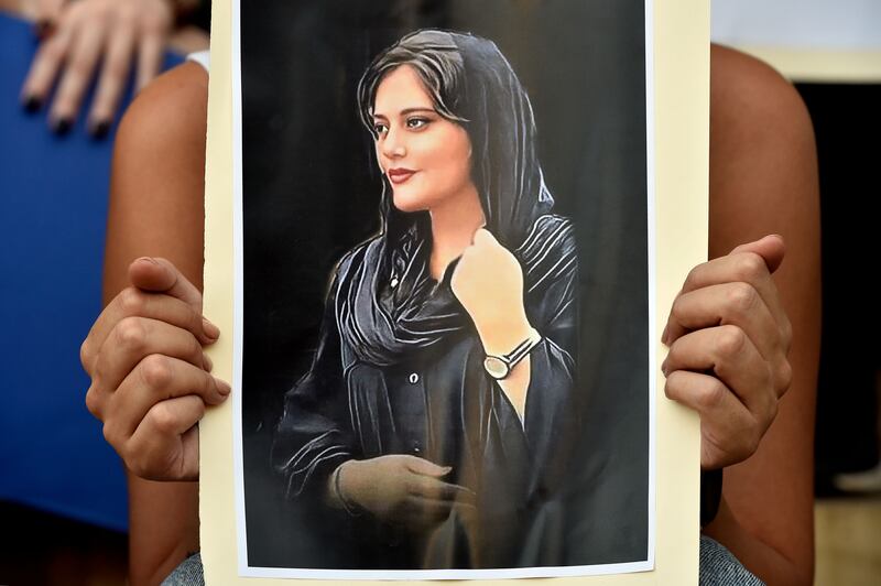 A Lebanese activist holds a poster depicting Mahsa Amini during a protest organized by feminist groups in support of women protesters in Iran. 