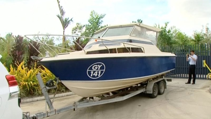 An officer takes pictures of a boat, which Australian police have seized in Cairns  in this still image taken from video on Tuesday.  Australian police have detained five men suspected of planning to sail a small boat from the far north to Indonesia and the Philippines en route to joining Islamic State in Syria. Photograph: Reuters