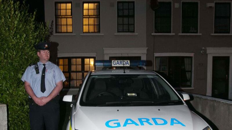 A  garda at the scene  in  Millrose Estate, Bluebell,   Dublin, where the remains of two men in their 70s were found on Tuesday. Photograph: Gareth Chaney Collins