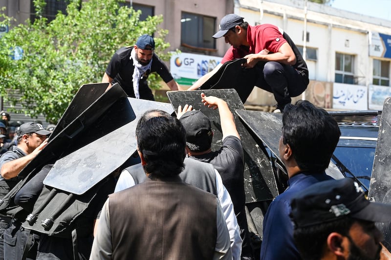 Security personnel use bullet proof shields to protect Pakistan's former prime minister Imran Khan as he arrives at the high court in Islamabad.  Photograph: Aamir Qureshi/ AFP 