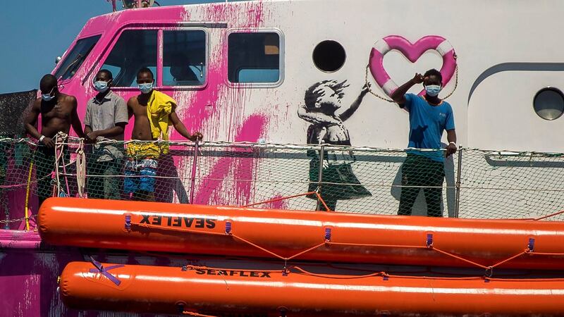 A boy waves to the crew of the Astral rescue vessel from the deck of the Louise Michel rescue vessel, a French patrol boat currently manned by activists and funded by the renowned artist Banksy in the central Mediterranean sea, at 50 miles south from Lampedusa on Friday. Photograph:  Santi Palacios/AP