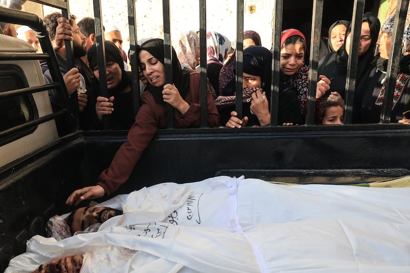 A woman reaches out to touch the bodies of members of the Faojo family, killed in an Israeli bombing on Rafah in the southern Gaza Strip, during their funeral on November 11th. Photograph: Said Khatib/AFP via Getty Images