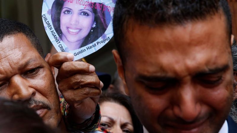 A supporter holds aloft an image of Anni Dewani as her distraught brother Anish Hindocha  leaves  court with family members in Cape Town on Monday after Shrien Dewani was acquitted. Photograph: Mike Hutchings/Reuters