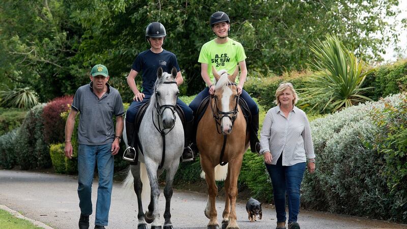 Kieran and Mairéad Ryan with their twin sons James (left) and Ivan who will compete in a number of working hunter pony classes at the Dublin Horse Show. Photograph: Dave Meehan for The Irish Times