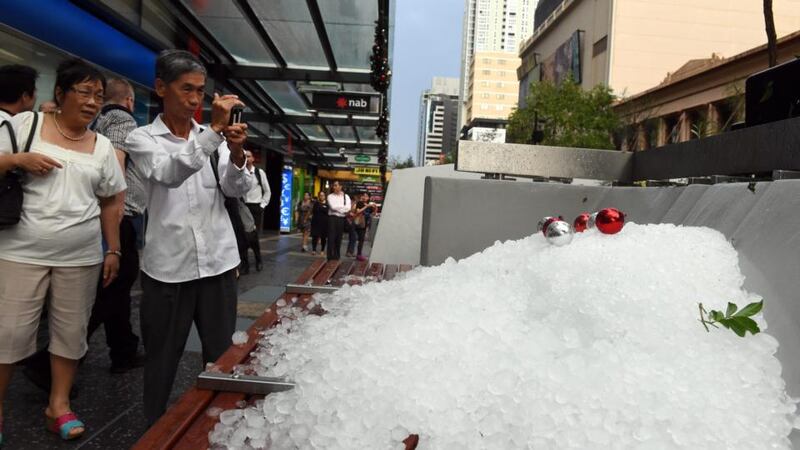 People take photos of a pile of hail stones in Brisbane’s central business district  after a severe thunderstorm swept through the city. Photograph: Dan Peled/EPA.