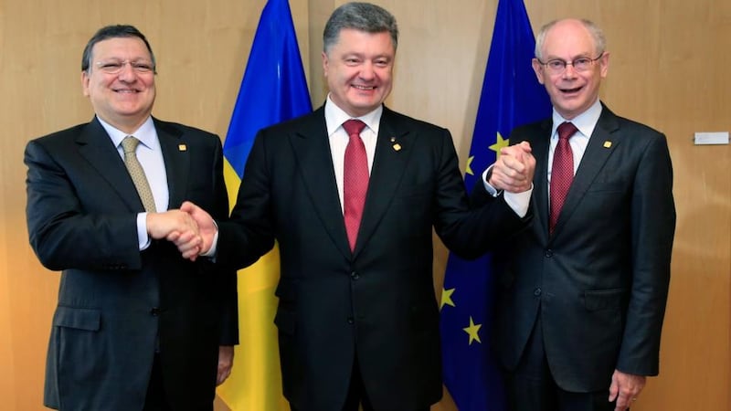 Ukraine’s president Petro Poroshenko (C) poses with European Commission president Jose Manuel Barroso (L) and European Council president Herman Van Rompuy (R) at the EU Council in Brussels today. Photograph: Stringer/Reuters .