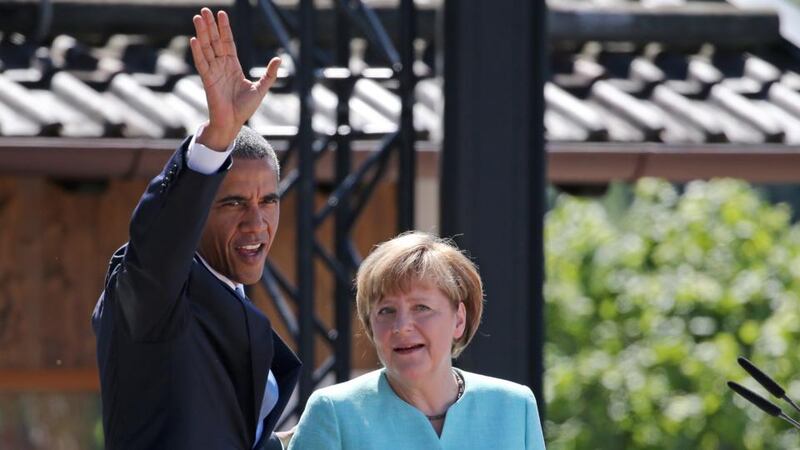 US president Barack Obama (L) waves next to Germany’s chancellor Angela Merkel (R) after delivering a speech upon arrival for a breakfast meeting with local citizens in Kruen near Garmisch-Partenkirchen in  southern Germany. Photograph: Daniel Karmann/AFP/Getty Images.