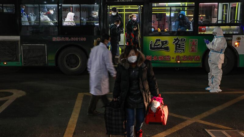 Patients displaying mild symptoms of the novel coronavirus arrive at an exhibition centre converted into a hospital in Wuhan. Photograph: STR/AFP via Getty Images