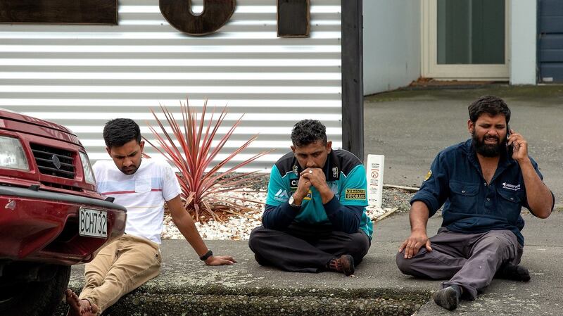 Grieving members of the public sit on a curb following a shooting resulting in multiple fatalities and injuries at the Masjid Al Noor mosque  in Christchurch. Photograph: Martin Hunter/PA