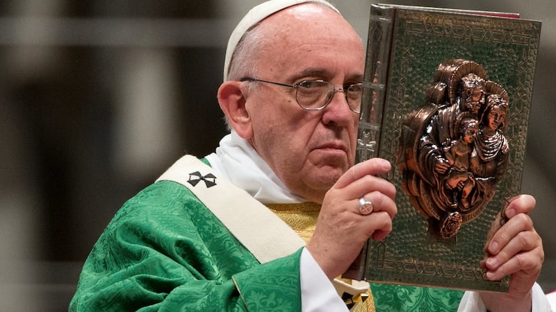 Pope Francis raises the book of the Gospels as he celebrates the opening Mass of the Synod of bishops, in St Peter’s Basilica at the Vatican, on Sunday. Photograph: AP