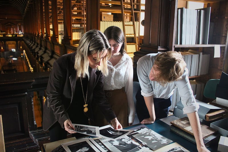 Hist auditor Aine Kennedy examining old records in the Old Library at Trinity with fellow Hist members Katy Harrington and Tom Francis.