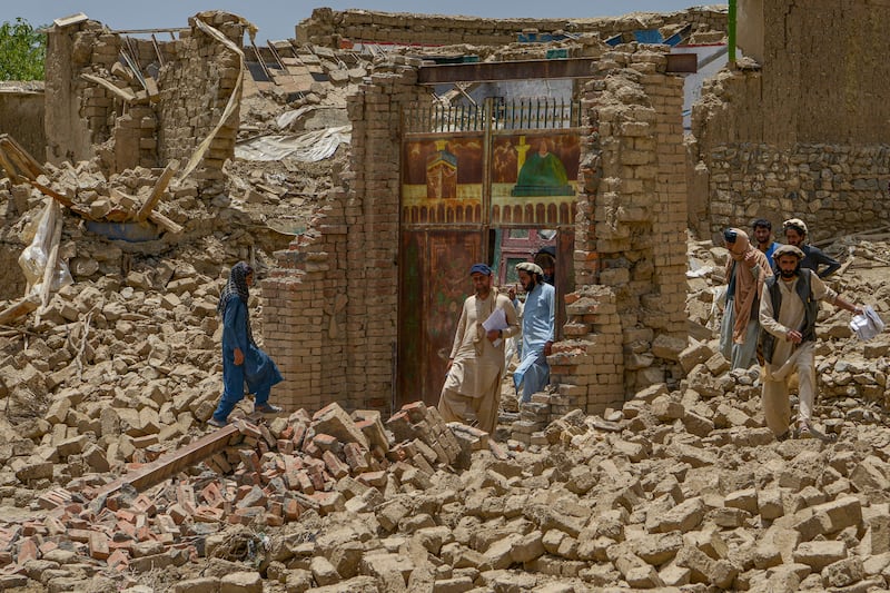 Villagers along with rescue workers examine the extent of damage at a village following an earthquake in Bernal district, Paktika province. Photograph: Ahmad Sahel Arman/AFP via Getty Images