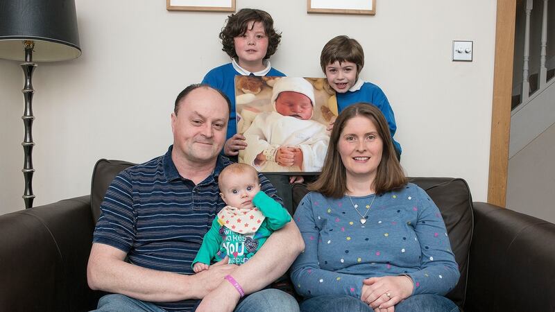 Anthony and Róisín Casey with their children, Aron (7), Darragh (5) and Sarah (6 months), with a picture of their daughter, Ellen, who was stillborn. Photograph: Dave Meehan