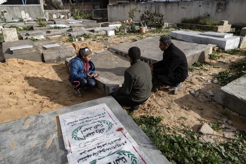 Hani al-Dibs and his children visit the grave of his eight-year-old son Hasib in northern Gaza. Photograph: Saher Alghorra/New York Times