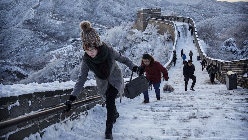 Chinese tourists walk on a slippery section of ice as snow is seen on the Great Wall after a snowfall on November 23, 2015 near Beijing, China. Photograph: Kevin Frayer/Getty Images)