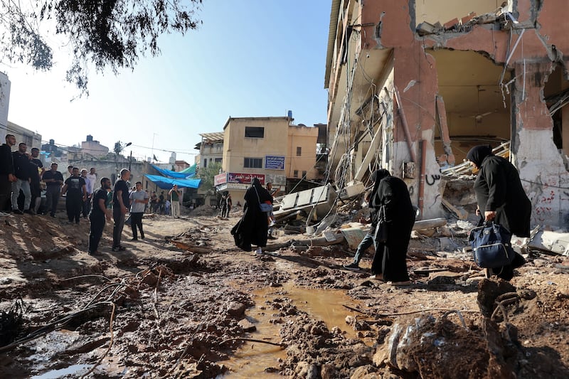 Palestinians walk next to a building damaged during a raid by Israeli troops at the Nur Shams refugee camp near the northern city of Tulkarm in the occupied West Bank on Friday. Photograph: Zain Jaafar/AFP via Getty Images