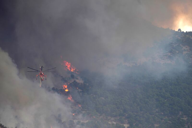 A helicopter flies towards a wildfire on Parnitha mountain in Acharnes, northern Athens. Photograph: Thanassis Stavrakis/AP