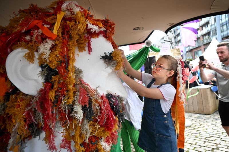 Lily Walker (9) from Blancharstown adds to Luke Kelly's beard with recycled wool from Avoca at an attraction at the Luke Kelly festival in Dublin city centre on Sunday. Photograph: Bryan Meade