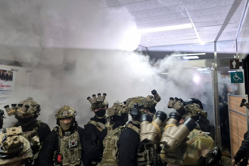 A National Assembly staff member sprays fire extinguishers to block soldiers entering the main hall of the National Assembly in Seoul, South Korea. Photograph: Jo Da-un/Yonhap via AP