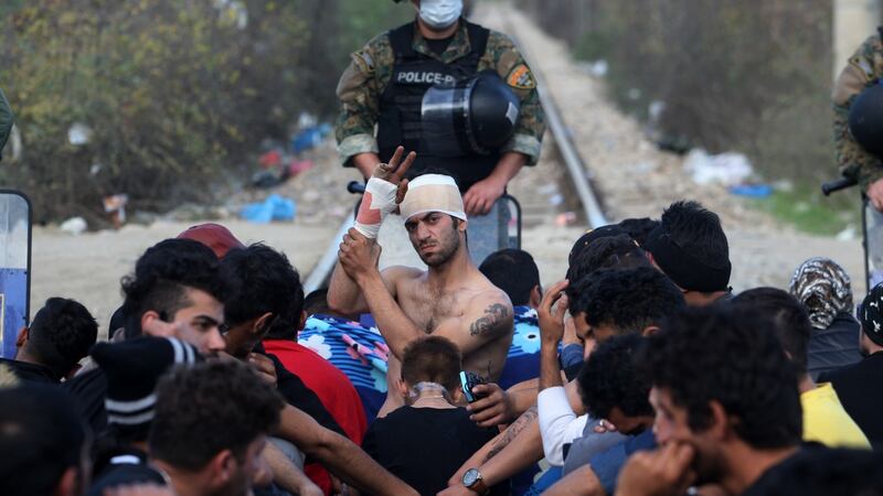 Protesters   sit on railway tracks as they wait to cross the Greek-Macedonian:   Rights groups have questioned Slovenia’s  policy of only granting passage to those fleeing conflict in Syria, Iraq and Afghanistan, warning asylum should be granted on merit, not on the basis of nationality Photograph: Sakis Mitrolidis/AFP/Getty