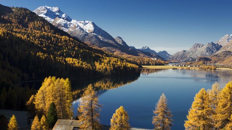 Snow-capped peaks and autumn leaves surround Lake Silvaplana in the Engadin region of Switzerland