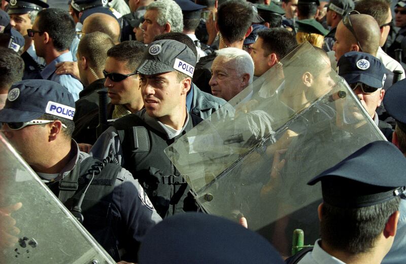 Opposition leader Ariel Sharon, flanked by security guards,  leaves the Al-Aqsa mosque compound in Jerusalem's Old City. The visit of Israel's current prime minister to Islam's third holiest shrine, also a sacred site for Jews known as Temple Mount, sparked the outbreak of the second intifada. Photograph: Awad Awad/Getty Images