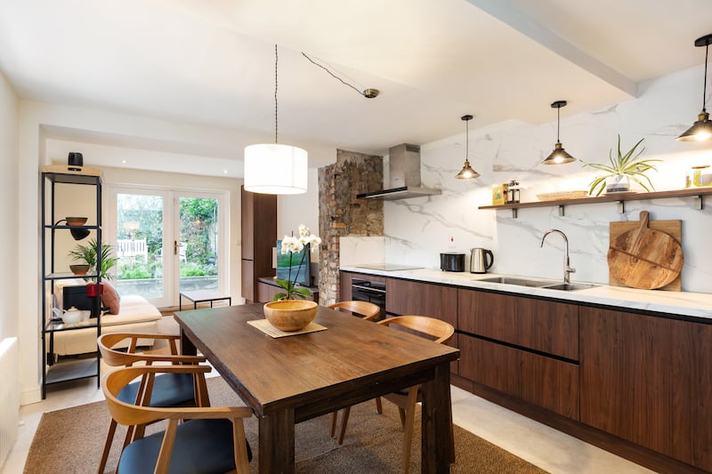 The kitchen, with a bank of walnut cabinetry on one wall