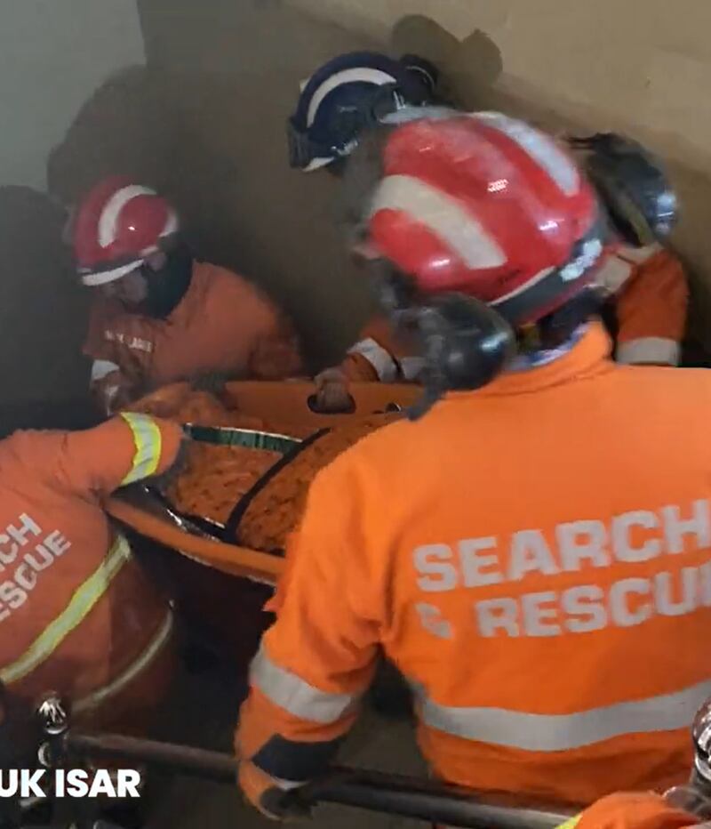 Screengrab from video of rescuers pulling a woman from the rubble of a building in Turkey. Photograph: FCDO/PA