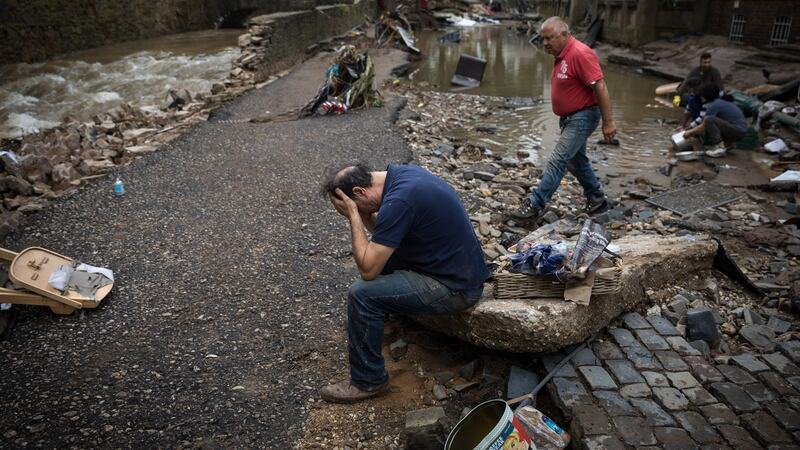 A restaurateur holds his head in his hands outside his business in Bad Münstereifelafter catastrophic flooding in west Germany. Photograph: New York Times