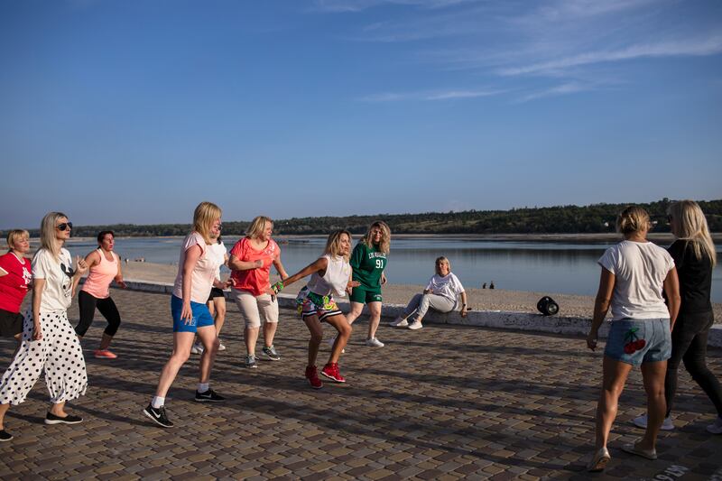 Oxana Naumenko runs her first open-air Zumba lessons for students after a year without teaching dance along the bank of the Dnieper river in Zaporizhzhia, Ukraine. Photograph: Diego Ibarra Sanchez/The New York Times
                      