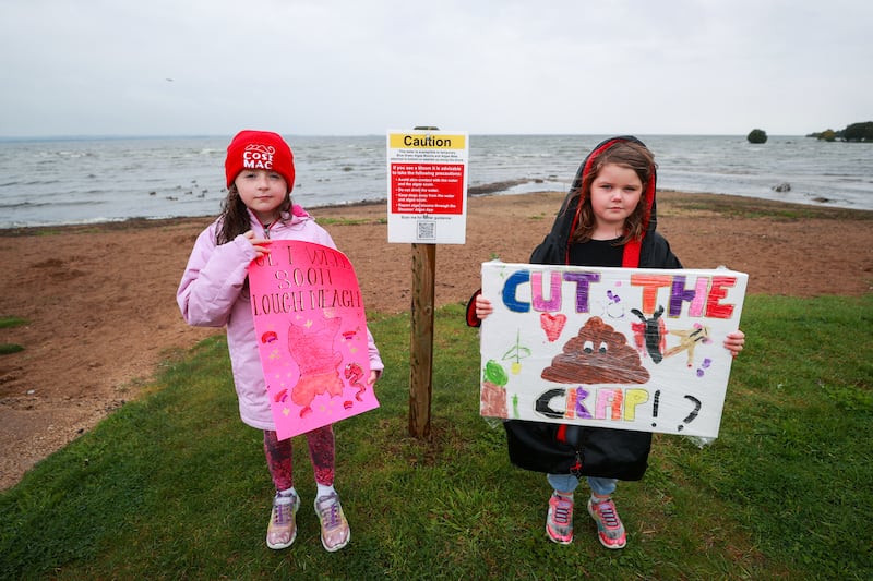 Kate O’Hagan (left) and Elsie-May Montague with homemade protest signs as environmental campaigners hold a 'wake' at Ballyronan beach for Lough Neagh last Sunday, amid claims toxic algae is killing the lake. Photograph: Liam McBurney/PA Wire