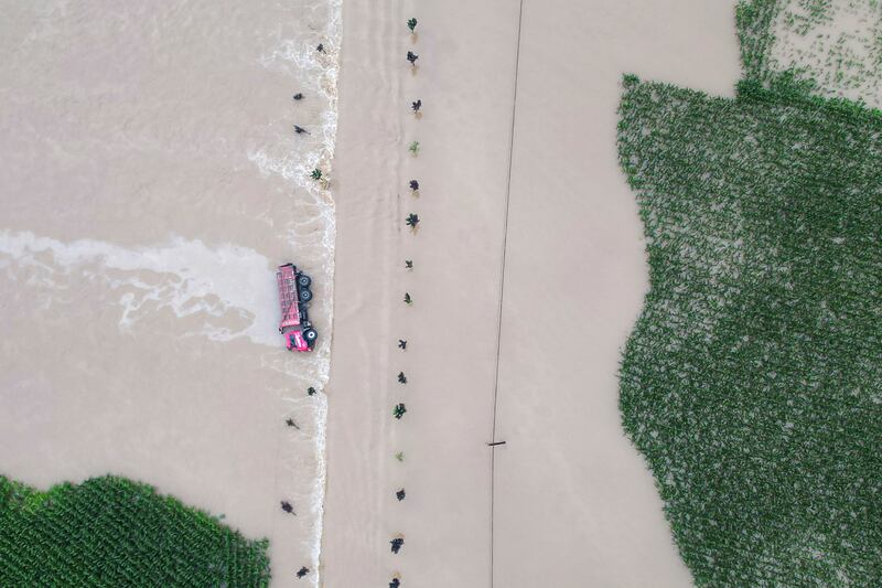 A truck turned on its side is seen as floodwaters flow across roads and fields in Kaiyuan Town of Shulan in northeastern China’s Jilin province. Photograph: Yan Linyun/Xinhua via AP