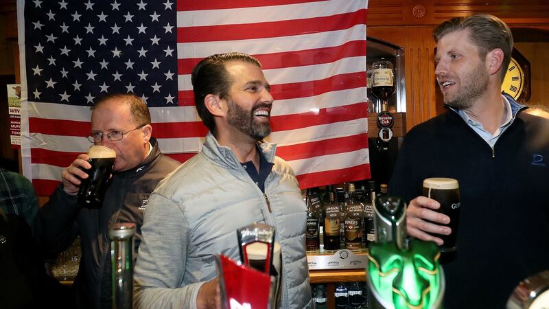 Donald Trump jnr (centre), and Eric Trump (right),  behind the bar in Tubridy’s Bar in the village of Doonbeg. Photograph: Brian Lawless/PA