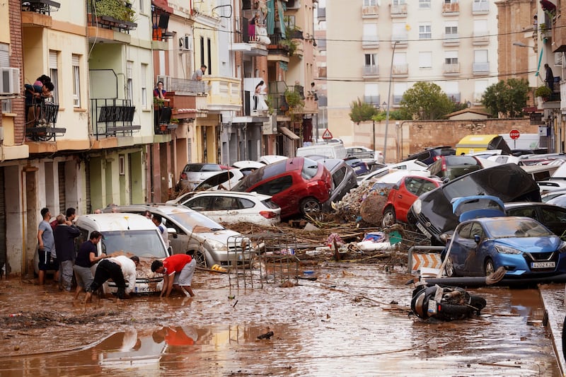 Spain floods: Residents look at cars piled up after being swept away by floods in Valencia. Photograph: Alberto Saiz/AP