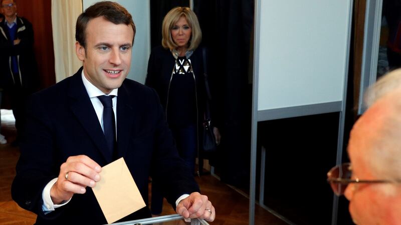 French presidential election candidate for the En Marche! movement Emmanuel Macron casts his ballot as his wife Brigitte Trogneux looks on, at a polling station in Le Touquet, northern France.  Photograph: Philippe Wojazer/AFP/Getty Images