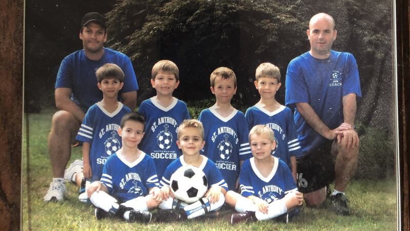 A wooden plaque with a photograph of an under-8 soccer team in 2007, Abe Hannigan a towheaded imp grinning in the middle row (3rd right), me a dome-headed character at the back in a shirt that helpfully said “coach”.