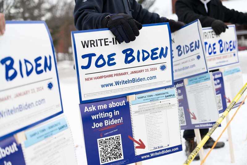 Volunteers hold signs outside Pinkerton Academy in Derry, New Hampshire on Tuesday. Photograph: Mel Musto/Bloomberg