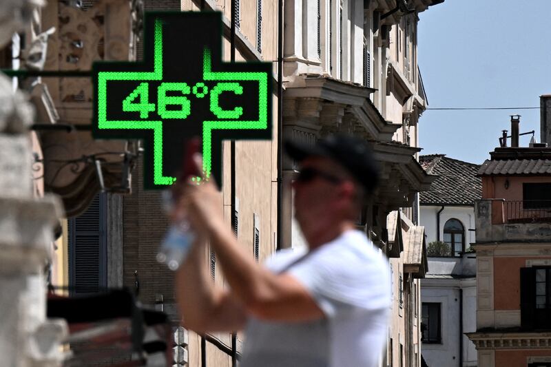 A tourist takes a picture in front of a pharmacy's sign indicating the current outside temperature near the Spanish Steps in Rome, on Tuesday. Photograph: Tiziana Fabi/AFP via Getty