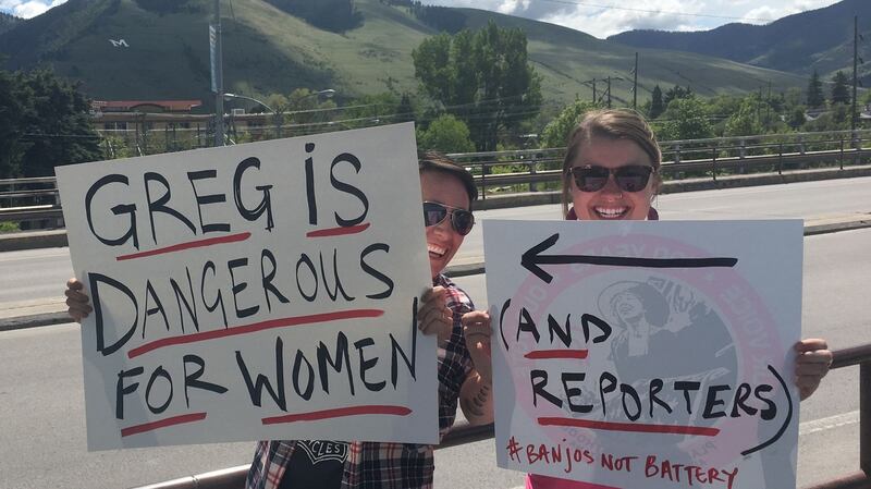 Two women in Missoula, Montana, hold up signs as people vote in a special congressional election on Thursday. The winning candidate, Republican Greg Gianforte, has been charged with assaulting a reporter. Photograph:  Ivan Couronne/AFP/Getty Images