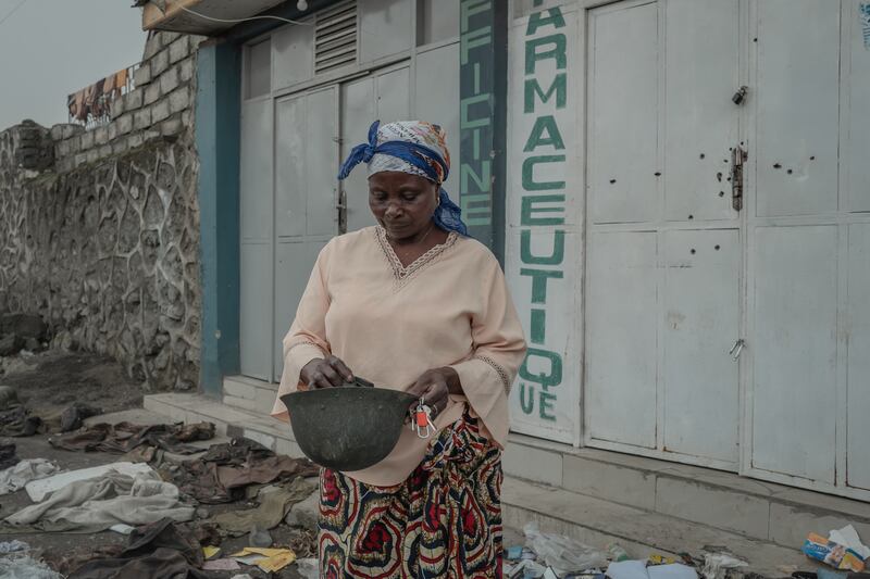 Anna Mapendo looks through debris outside her home in Goma. Photograph: Guerchom Ndebo/New York Times