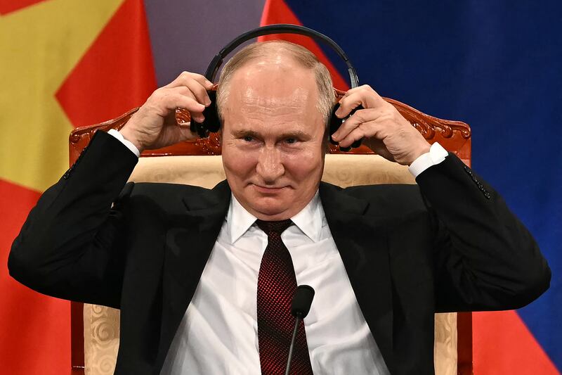 Vladimir Putin adjusts his headphones during an event with Vietnam's president To Lam at the Hanoi Opera House. Photograph:  Manan Vatsayana/AFP via Getty Images