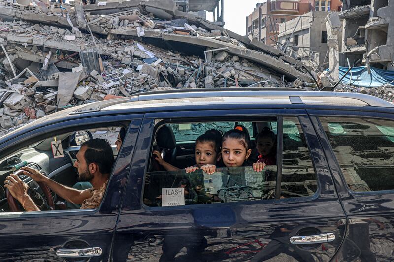 Palestinians drive amid the rubble of buildings destroyed in an Israeli air strike in Rafah on the southern Gaza Strip. Photograph: Said Khatib/AFP via Getty Images)