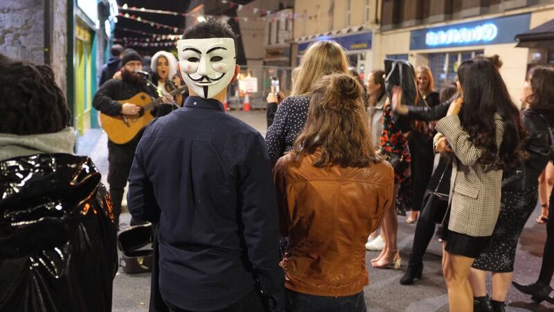 Onlookers join in singing with a busker in Galway city centre on Saturday Night. Photograph: Joe O Shaughnessy