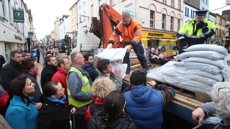 People collect sand bags from Cork County Council workers on Oliver Plunkett Street as they prepare for flooding this evening in Cork. Photograph: Niall Carson/PA