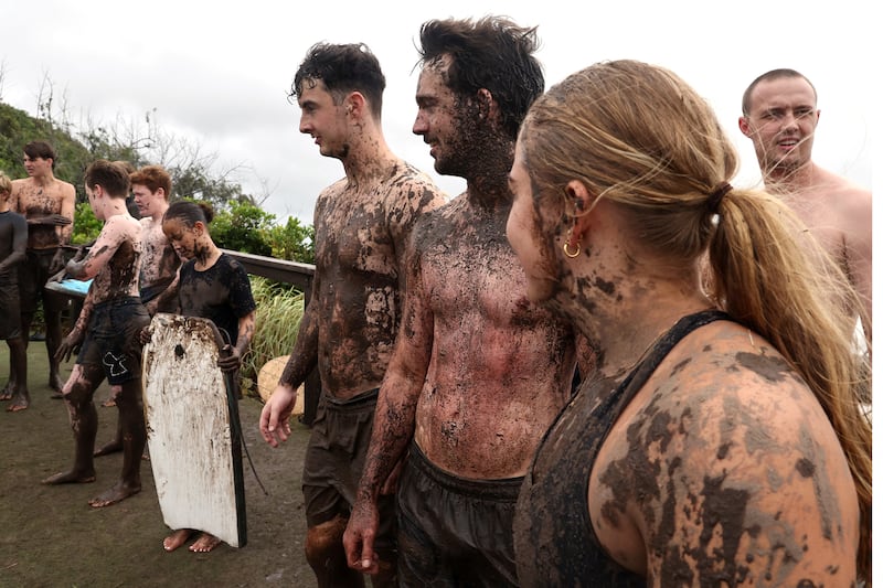 A group prepares to slide down a muddy hill at a park near Miami Beach, along the southern end of the Gold Coast. Photograph: David Gray/AFP      