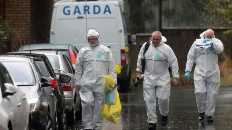 Deputy State Pathologist Dr Michael Curtis (left) at the scene where a two-year-old boy was found dead in Shankill yesterday. Photograph: Niall Carson/PA Wire