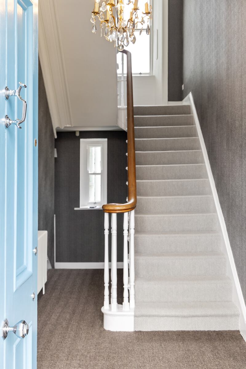 Entrance hall with herringbone sisal carpet and textured wallpaper