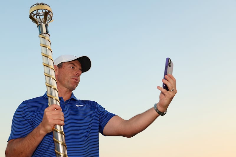 Rory McIlroy poses for a selfie with the DP World Tour Championship trophy on the 18th green. Photograph: Luke Walker/Getty