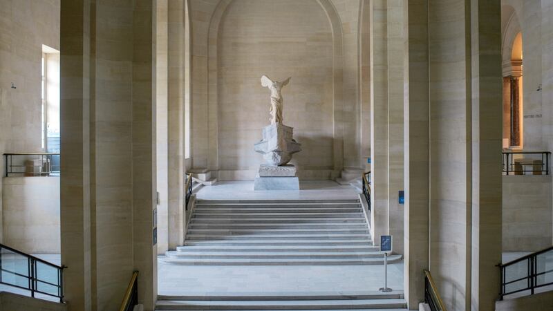 The Winged Victory of Samothrace floating quietly above a marble staircase at the Louvre. Photograph:  Dmitry Kostyukov/The New York Times